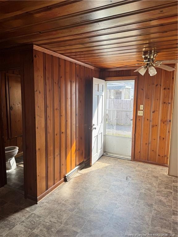 interior space with wooden ceiling, ceiling fan, and wood walls