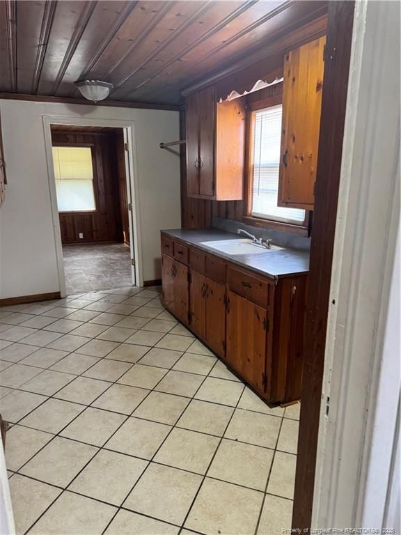 kitchen featuring light tile patterned floors, sink, and wooden ceiling