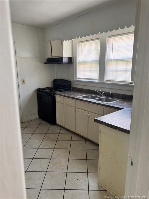 kitchen featuring black electric range, sink, and light tile patterned floors