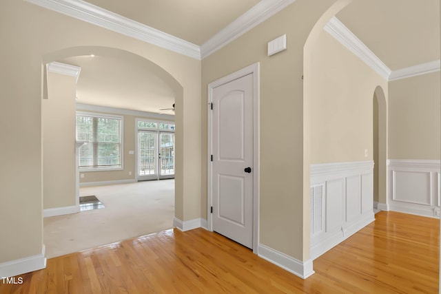 hall with crown molding and light hardwood / wood-style floors