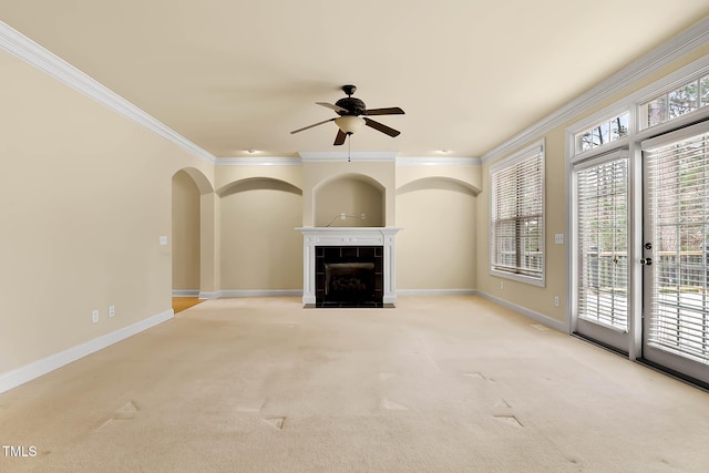 unfurnished living room with ceiling fan, light colored carpet, ornamental molding, and a tile fireplace