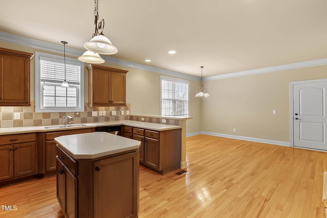 kitchen featuring sink, decorative light fixtures, plenty of natural light, and a kitchen island