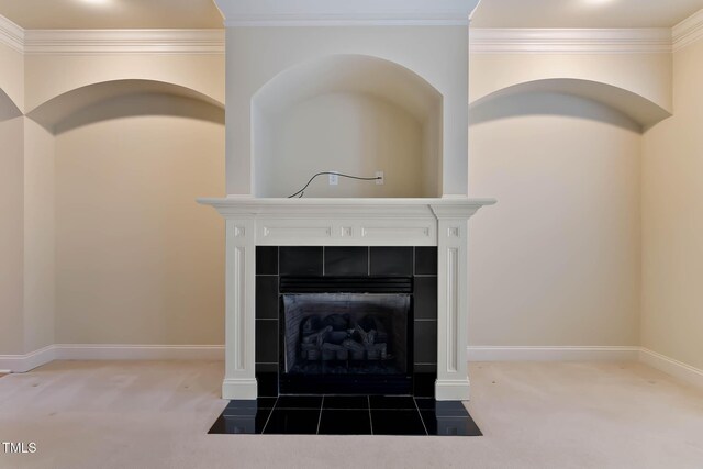 details featuring a tiled fireplace, ornamental molding, and carpet