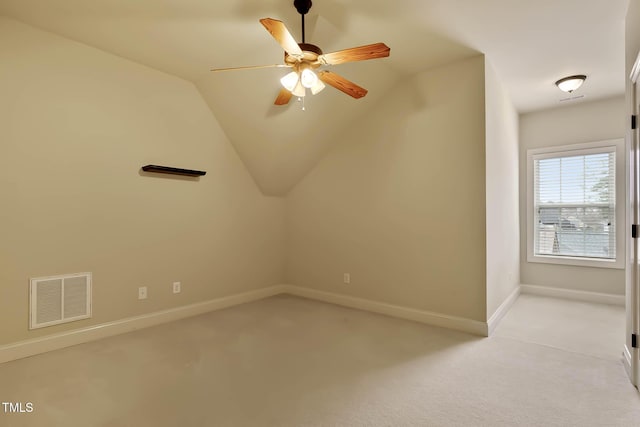 additional living space with vaulted ceiling, light carpet, and ceiling fan