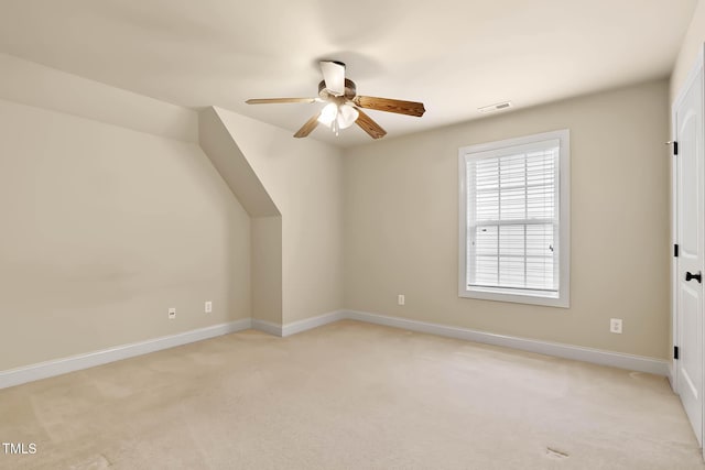 additional living space featuring light carpet and ceiling fan