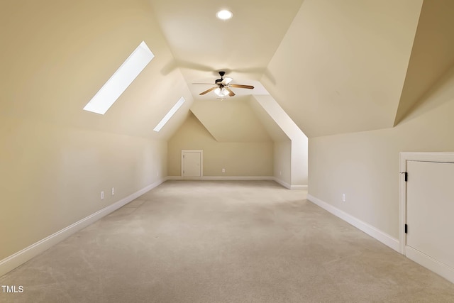 bonus room with ceiling fan, light colored carpet, and lofted ceiling with skylight