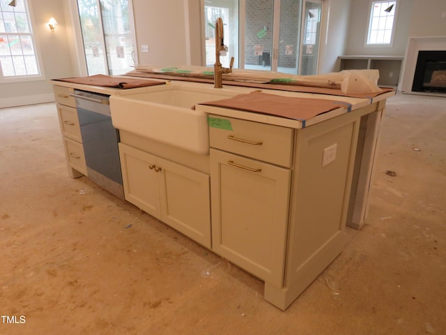 kitchen with a healthy amount of sunlight, a fireplace, open floor plan, and stainless steel dishwasher