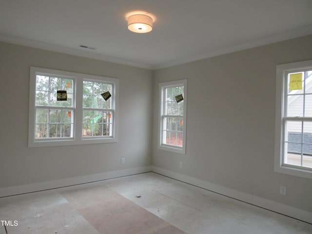 spare room featuring baseboards, visible vents, and ornamental molding