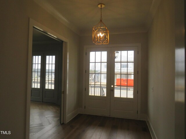 doorway to outside with crown molding, a notable chandelier, french doors, and baseboards