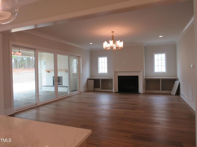 unfurnished living room with crown molding, plenty of natural light, and wood finished floors