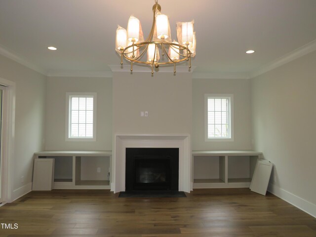 unfurnished living room with an inviting chandelier, crown molding, wood finished floors, and a healthy amount of sunlight