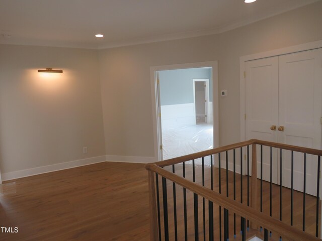 corridor with recessed lighting, baseboards, wood finished floors, and crown molding