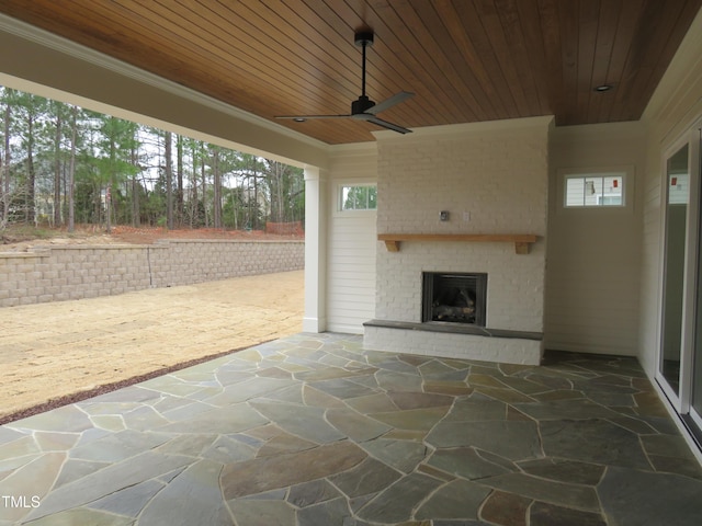 view of patio featuring a ceiling fan and an outdoor brick fireplace