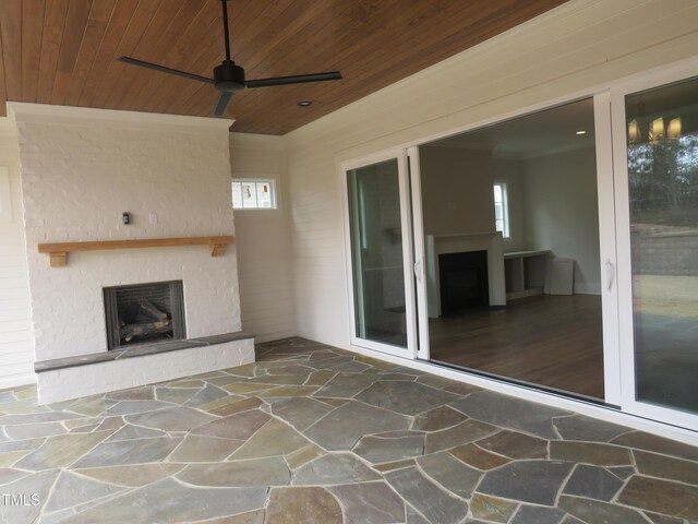view of patio / terrace featuring a brick fireplace and ceiling fan