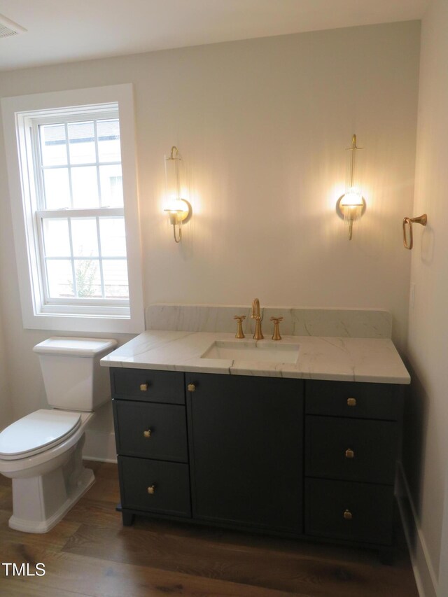 bathroom featuring vanity, toilet, wood finished floors, and visible vents