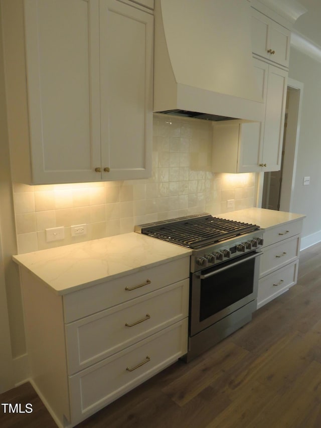 kitchen with dark wood finished floors, white cabinets, tasteful backsplash, and high end stainless steel range