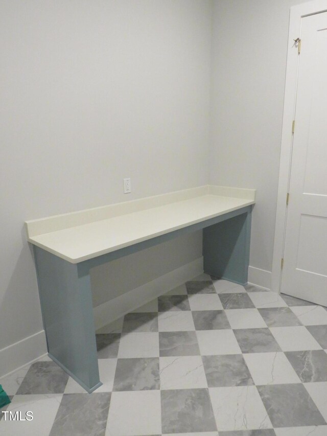 unfurnished office with built in desk and baseboards
