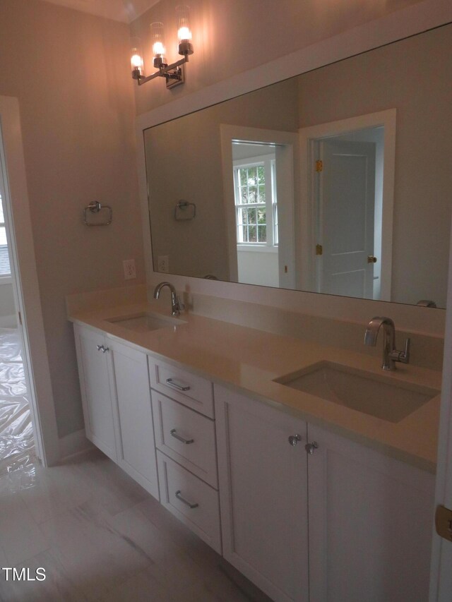 full bathroom with a sink, a chandelier, and double vanity