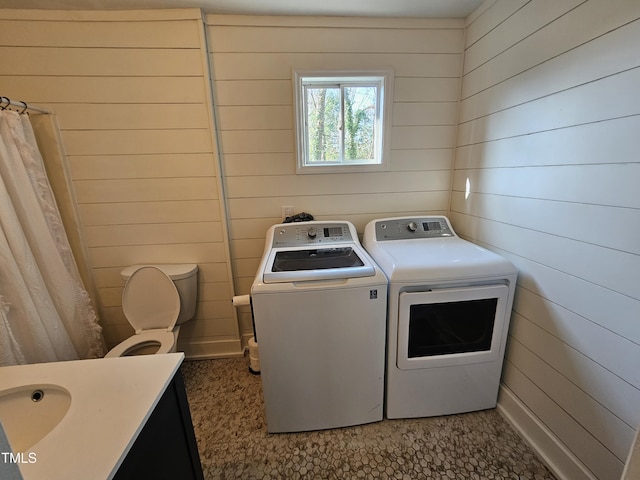 washroom featuring separate washer and dryer and wood walls