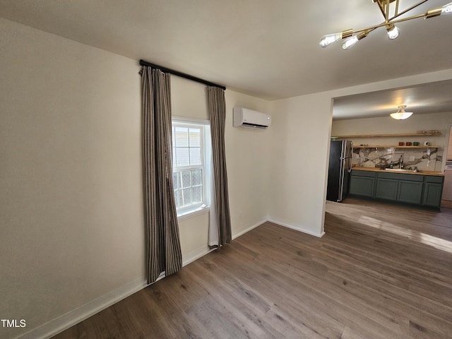 spare room featuring sink, dark hardwood / wood-style floors, and an AC wall unit