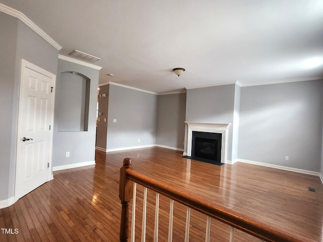 unfurnished living room with crown molding and dark wood-type flooring