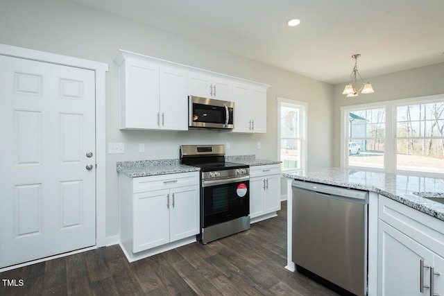 kitchen featuring stainless steel appliances, dark hardwood / wood-style floors, pendant lighting, and white cabinets