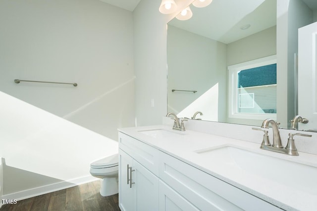 bathroom with vanity, toilet, and hardwood / wood-style floors