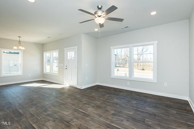 interior space with ceiling fan with notable chandelier and dark hardwood / wood-style floors