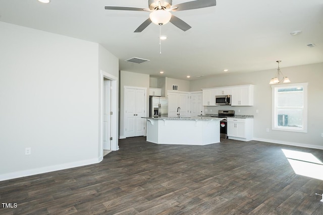 kitchen with white cabinetry, decorative light fixtures, a center island with sink, dark hardwood / wood-style floors, and stainless steel appliances