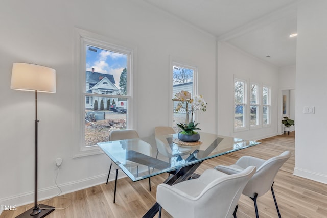 dining area featuring ornamental molding and light hardwood / wood-style flooring