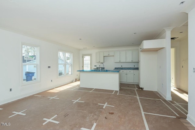 kitchen featuring a kitchen island with sink, sink, and white cabinetry