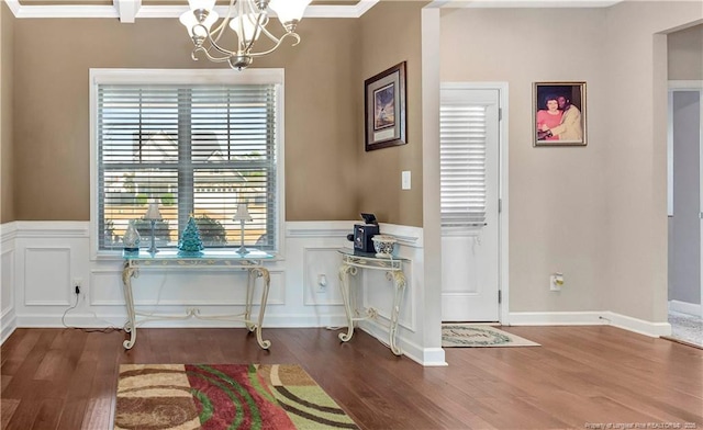 dining space featuring hardwood / wood-style flooring, crown molding, and an inviting chandelier