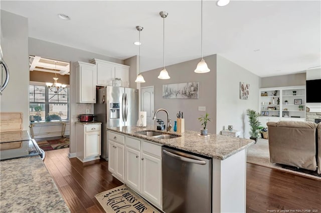 kitchen with sink, hanging light fixtures, stainless steel appliances, light stone countertops, and white cabinets