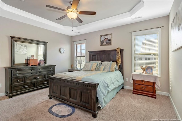 bedroom featuring light colored carpet, a raised ceiling, and ceiling fan