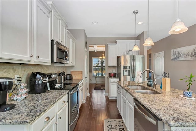 kitchen featuring decorative light fixtures, stainless steel appliances, and white cabinets