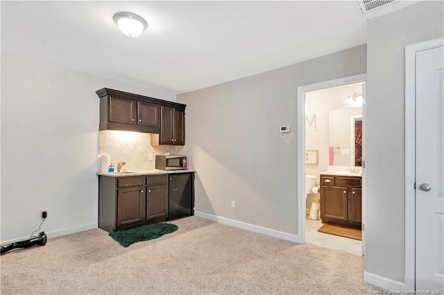 kitchen featuring light colored carpet, dark brown cabinetry, and backsplash