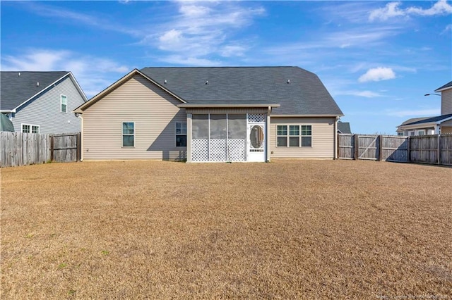 rear view of property featuring a sunroom and a yard