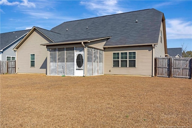 rear view of property featuring a lawn and a sunroom