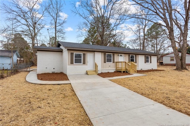 ranch-style house featuring fence, roof with shingles, a front lawn, crawl space, and brick siding