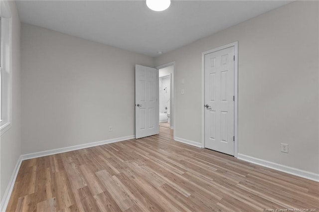 spare room with light wood-style flooring and baseboards