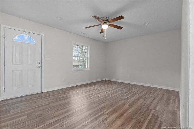 foyer with visible vents, wood finished floors, baseboards, and ceiling fan