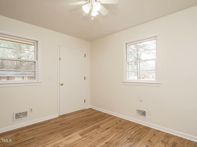 spare room with ceiling fan, light hardwood / wood-style floors, and a wealth of natural light