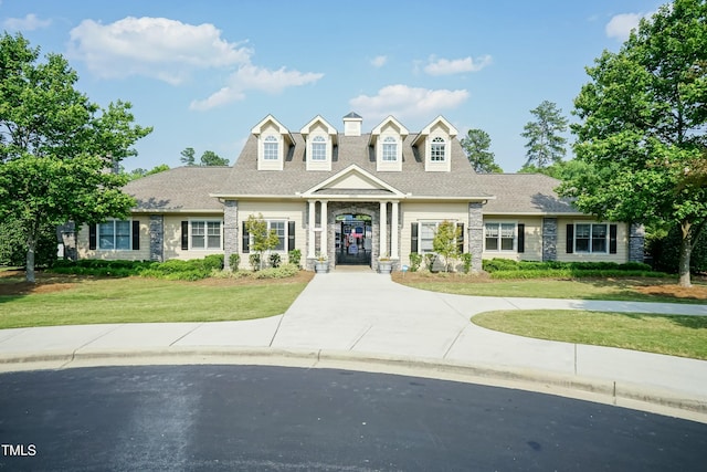 cape cod house with a front yard