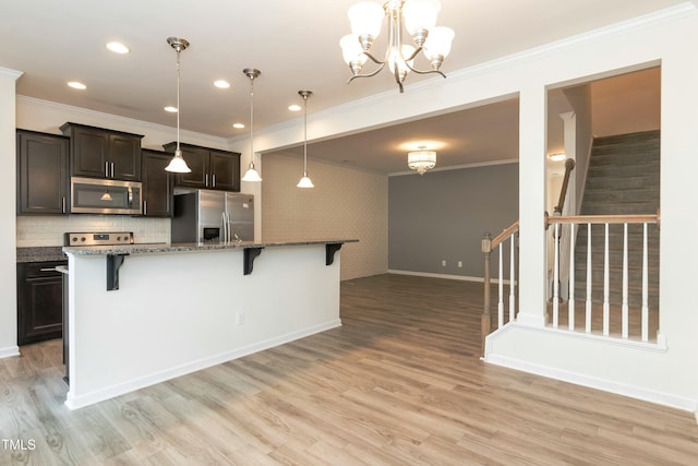 kitchen with pendant lighting, dark stone countertops, stainless steel appliances, a kitchen breakfast bar, and a center island