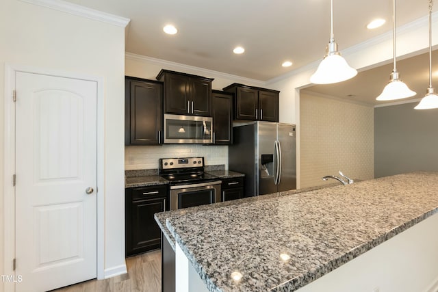 kitchen with decorative light fixtures, ornamental molding, appliances with stainless steel finishes, light stone countertops, and light hardwood / wood-style floors