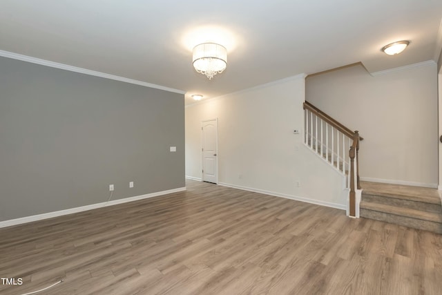 spare room with hardwood / wood-style floors, ornamental molding, and a chandelier