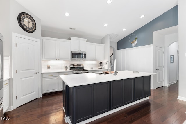 kitchen featuring sink, appliances with stainless steel finishes, dark hardwood / wood-style flooring, a kitchen island with sink, and white cabinets