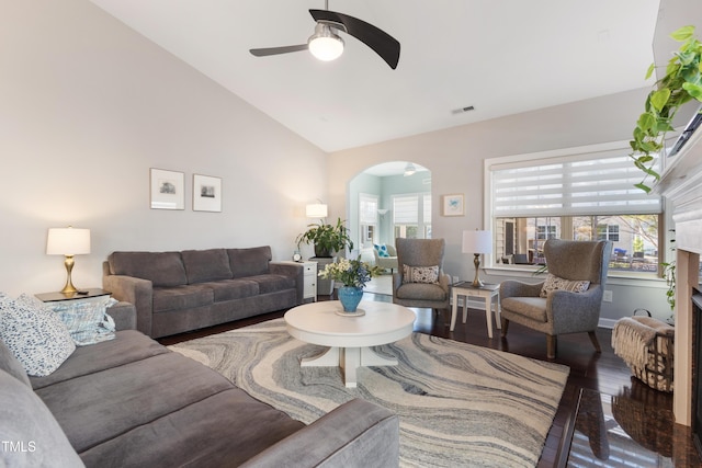 living room with dark wood-type flooring, ceiling fan, and lofted ceiling