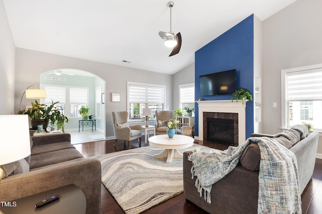 living room with ceiling fan, high vaulted ceiling, a fireplace, and dark hardwood / wood-style flooring