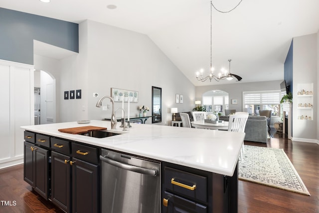 kitchen with an island with sink, sink, dark hardwood / wood-style flooring, hanging light fixtures, and stainless steel dishwasher